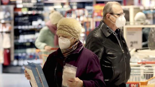 Seniori sa chránia respirátorom FFP2 počas nákupu v supermarkete.