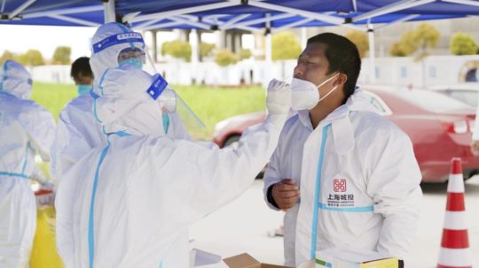 Zamestnanec počas testovania na ochorenie COVID-19 v čínskom Šanghaji.
