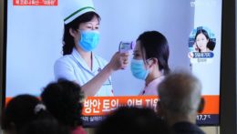Cestujúci sledujú na televíznej obrazovke správy o výskyte ochorenia COVID-19 v Severnej Kórei.