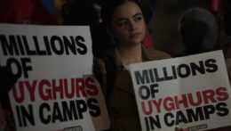 Protestujúca drží plagát s nápisom "Milióny Ujgurov v táboroch".