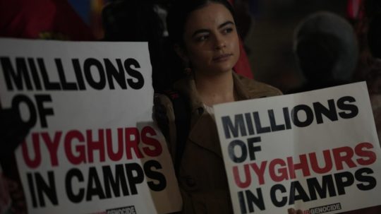 Protestujúca drží plagát s nápisom "Milióny Ujgurov v táboroch".