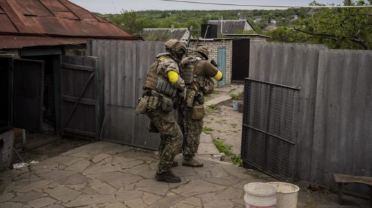Príslušníci ukrajinskej Národnej gardy zaujímajú pozície počas prieskumnej misie v dedine na predmestí Charkova.