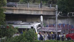 Policajti a záchranári stoja na mieste nehody vlakov v Sant Boi neďaleko Barcelony.