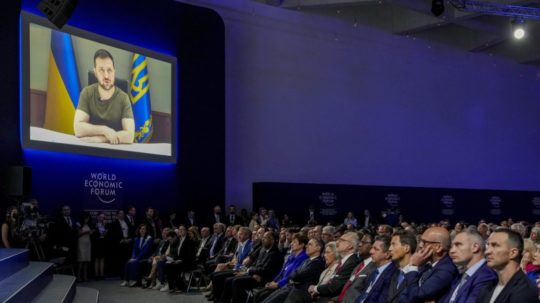 Na veľkoplošnej obrazovke je ukrajinský prezident Volodymyr Zelenskyj počas on-line prejavu z Kyjeva na výročnom Svetovom ekonomickom fóre (WEF) vo švajčiarskom Davose.