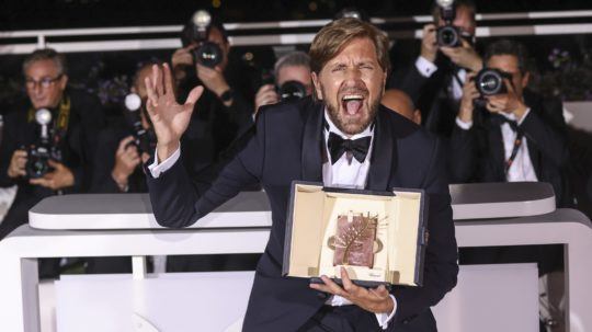 Na snímke sa švédsky režisér Ruben Östlund teší zo zisku Zlatej palmy a s ocenením pózuje pred novinármi.