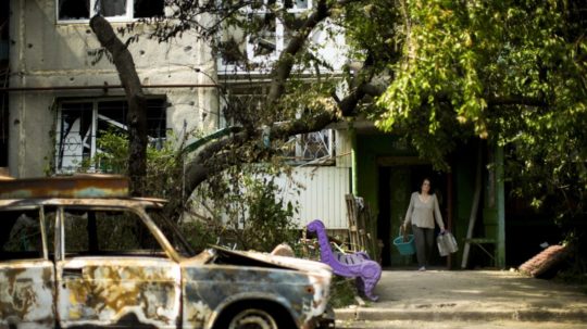Žena opúšťa svoj byt v obytnej budove zničenej po nočnom ostreľovaní v meste Sloviansk na Donbase.