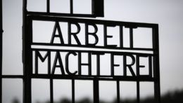 Brána bývalého nacistického tábora smrti Sachsenhausen s nápisom "Arbeit macht frei".
