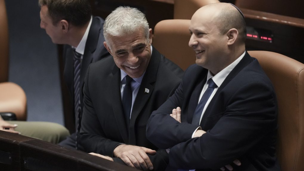Dosluhujúci izraelský premiér Naftali Bennett (vpravo) a izraelský minister zahraničných vecí Yair Lapid (vľavo) sa usmievajú pred hlasovaním o rozpustení izraelského parlamentu (Knesetu) v Jeruzaleme.