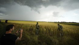 Zahraničný novinár fotí ruských vojakov, ktorí strážia územie vedľa poľa so pšenicou v Záporožskej oblasti na juhu Ukrajiny