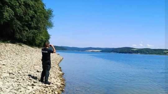 Ilustračná snímka - policajt stojí na brehu Domaše.
