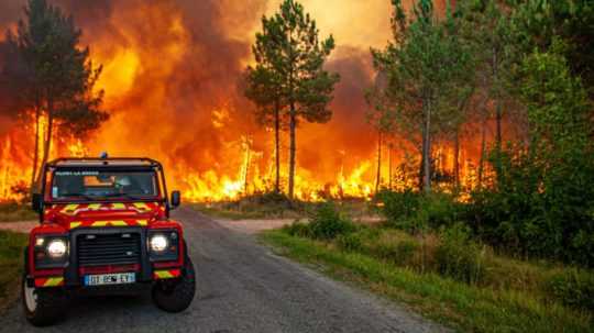 Na snímke plamene šíriace sa v lesnom poraste počas lesného požiaru pri obci Landiras na juhozápade Francúzska 13. júla 2022.