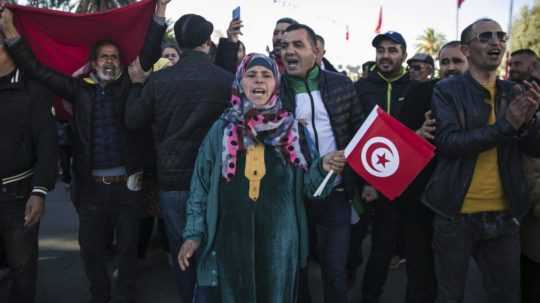Na snímke Tunisania počas protestu proti prezidentovi Kaísovi Saídovi pri príležitosti 10. výročia arabskej jari.