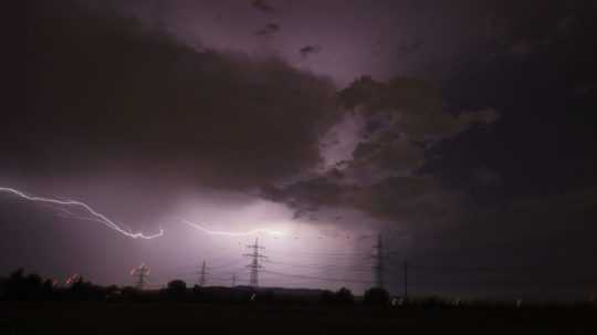 Ilustračná snímka-búrka vytvára siluetu elektrického vedenia.