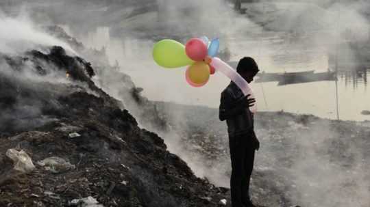 chlapec s balónmi na skládke odpadu