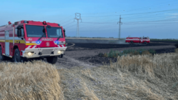 hasičské autá na horiacom poli s obilím