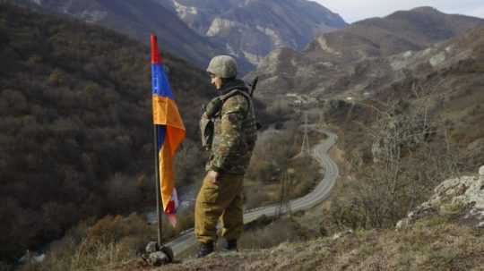 Na snímke stojí etnický arménsky vojak pri zástave Náhorného Karabachu na vrchu neďaleko kontrolného stanovišťa pri dedine Čarektar