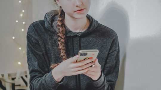 Na ilustračnej snímke dievča s telefónom.