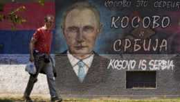 Muž prechádza okolo graffiti zobrazujúceho ruského prezidenta Vladimira Putina: "Kosovo je Srbsko".
