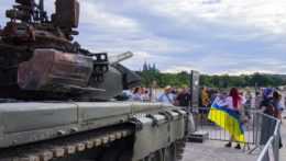 ľudia sa fotia pred zničeným tankom v Prahe