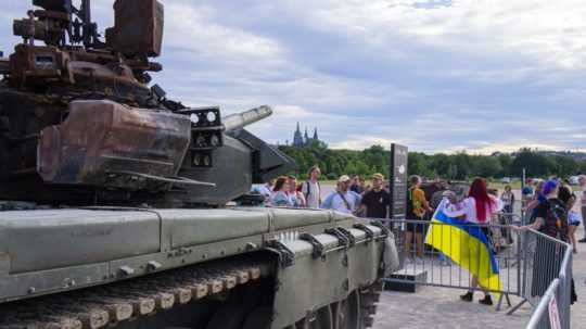 ľudia sa fotia pred zničeným tankom v Prahe