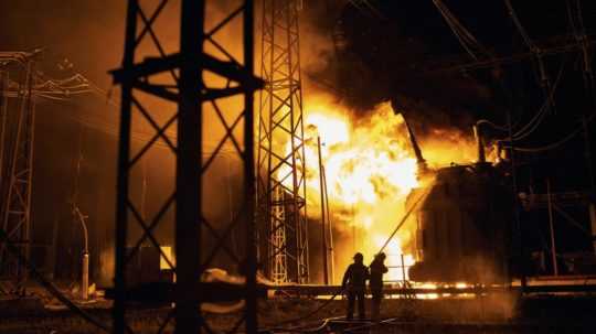 Na snímke ukrajinskí hasiči hasia požiar elektrárne po zásahu ruskou raketou v meste Charkov.