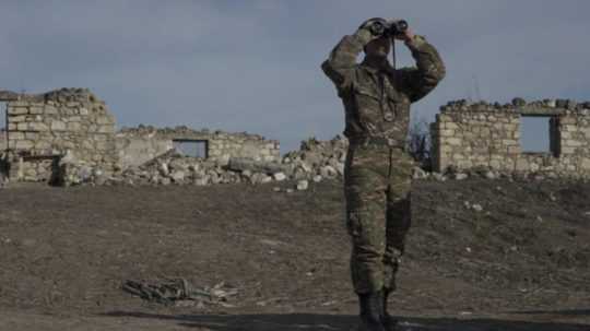 vojak sa pozerá cez ďalekohľad