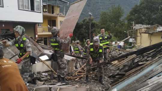 Vojaci odstraňujú trosky budov počas pátrania po preživších po zemetrasení.