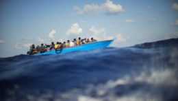 Africkí migranti na drevenej loďke v Stredozemnom mori.