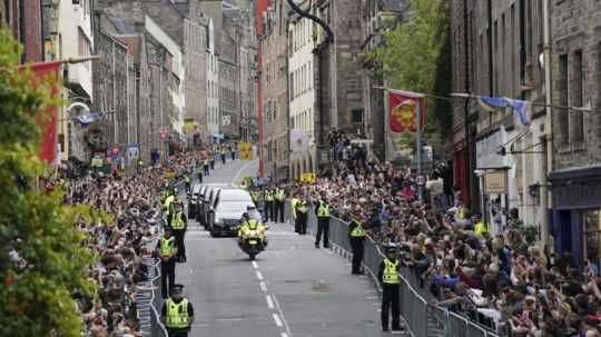 Na snímke pohrebné vozidlo vezie rakvu s pozostatkami zosnulej britskej kráľovnej Alžbety II. ulicami Edinburghu.