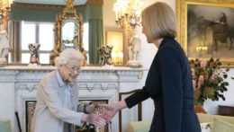 Na snímka sprava novozvolená líderka britskej Konzervatívnej strany Liz Trussová a britská kráľovná Alžbeta II. si podávajú ruky počas audiencie na zámku Balmoral.