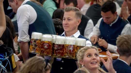Čašník nesie pivá v jednom z pivných stánkov počas otvorenia 187. tradičného mníchovského pivného festivalu Oktoberfest v Mníchove.