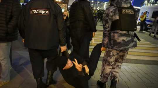 Policajti zatýkajú demonštranta počas protestu proti mobilizácii v Moskve.