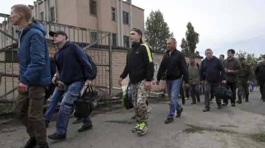 Ruskí branci kráčajú okolo vojenského náborového centra v ruskom Volgograde.