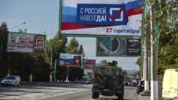 Vojenské vozidlo prechádza okolo bilbordu s nápisom "S Ruskom navždy, 27. september" pred referendom o pripojení Luhanskej samozvanej republike na východe Ukrajiny k Rusku.