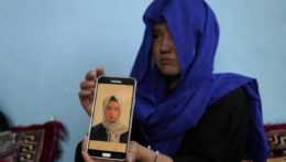 Na snímke afganské dievča ukazuje fotografiu svojej sestry, ktorá zahynula počas útoku samovražedného atentátnika v súkromnom vzdelávacom centre v Kábule.