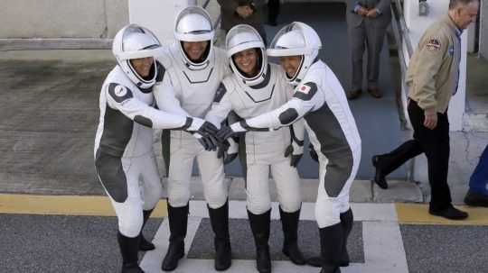 Na snímke sú členovia posádky rakety Crew Dragon pred budovou NASA.