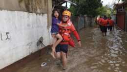 Záchranár nesie dievčatko počas evakuácie obyvateľstva vo filipínskom Hilongose.