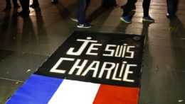 Na snímke je francúzska vlajka na zemi s nápisom "Je suis Charlie" (Som Charlie).