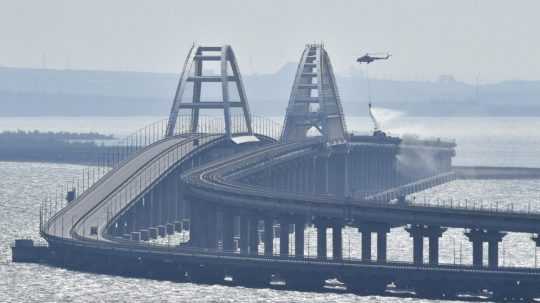Na snímke vrtuľník hasí požiar na Kerčskom moste spájajúcom ruskú pevninu a Krymský polostrov nad Kerčským prielivom v Kerči.