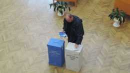 muž vhadzuje lístok do volebnej urny