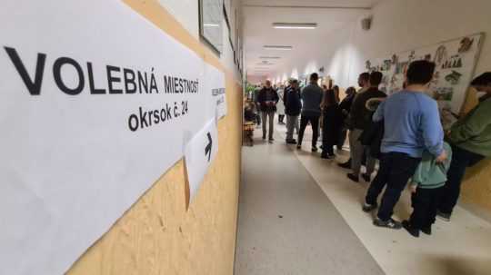 Voliči stoja na chodbe pred volebnými miestnosťami na základnej škoíle v Bratislave