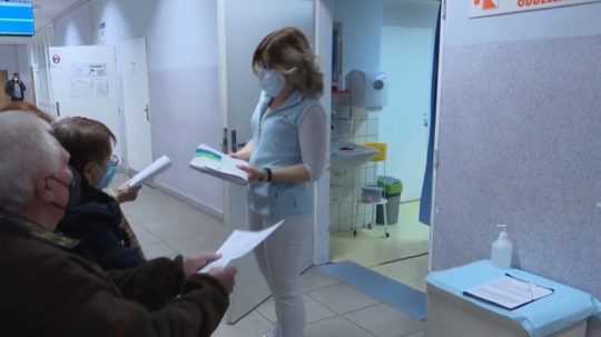Na snímke lekárka v čakárni preberá od pacientov zdravotné karty.