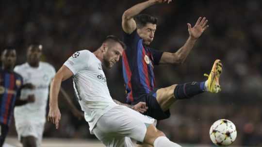 Milan Škriniar z Interu Miláno v súboji s Robertom Lewandowskim z FC Barcelona.