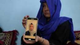 Na snímke afganské dievča ukazuje fotografiu svojej sestry, ktorá zahynula počas útoku.