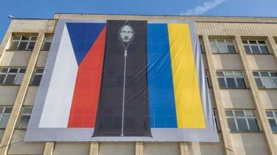 Na snímke je podobizeň Vladimira Putina vo vaku na mŕtvoly medzi českou a ukrajinskou zástavou na budove českého ministerstva vnútra v Prahe.