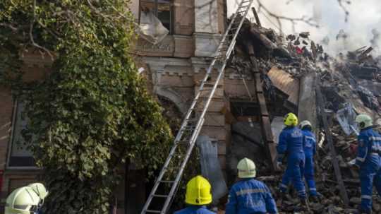 hasiči zasahujú v zničenej bytovke v Kyjeve