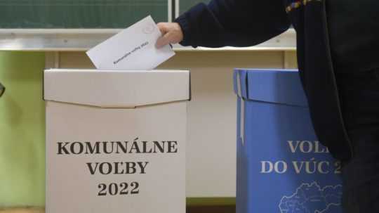 muž hádže hlasovací lístok do volebnej urny
