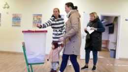 Ľudia hlasujú vo volebnej miestnosti počas parlamentných volieb v Lotyšsku 1. októbra 2022 v Rige.