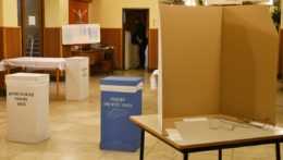 prázdna volebná miestnosť s plentou a modrou a bielou volebnou urnou