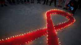 Na snímke nepálske ženy a deti zapaľujú sviečky v predvečer Svetového dňa boja proti AIDS v indickom Káthmandu.